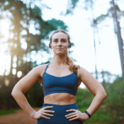 Athletic woman wearing earbuds in forest