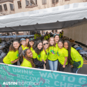 Smiling volunteers in neon shirts at Austin Marathon