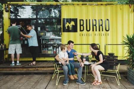 Family dining outside yellow Burro Cheese Kitchen Family dining outside yellow Burro Cheese Kitchen