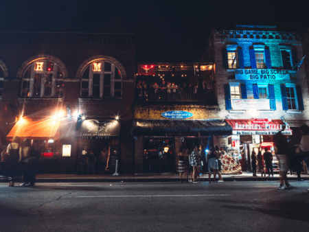 Nighttime downtown street with bars and crowd Nighttime downtown street with bars and crowd