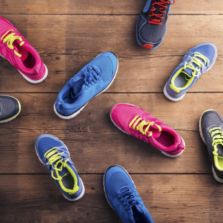 Colorful athletic shoes scattered on wooden floor