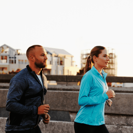 Couple jogging on urban waterfront path