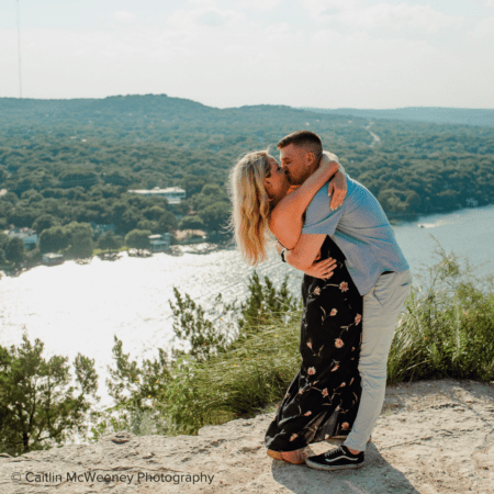 Couple kissing on cliff overlooking lake