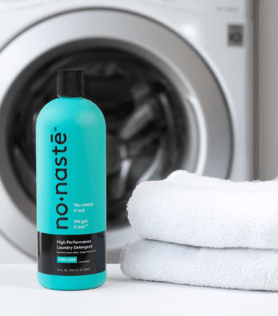 Turquoise laundry detergent bottle with folded towels