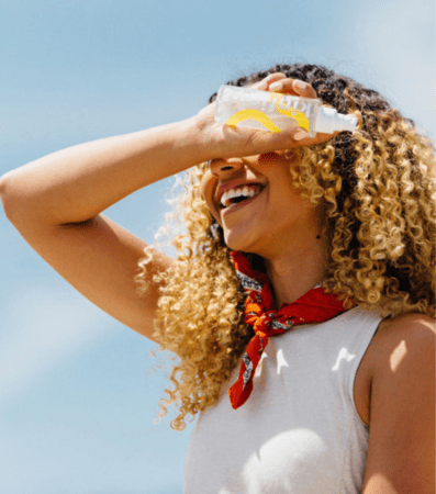 Smiling woman shading eyes with water bottle