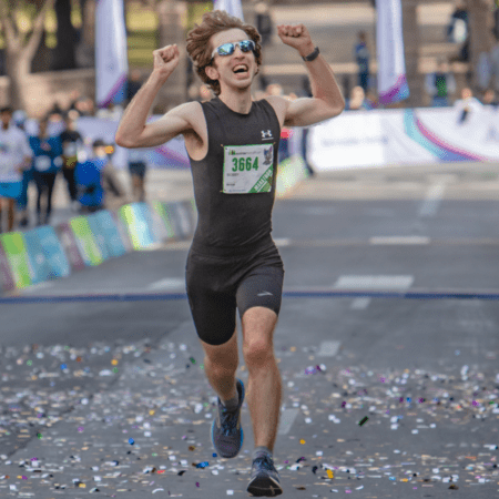 Runner celebrating victory at race finish line
