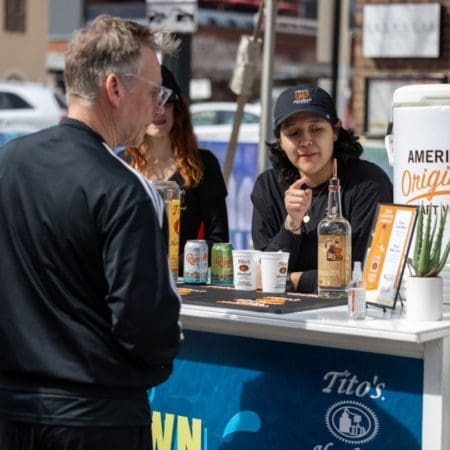 Woman serving drinks at outdoor festival booth