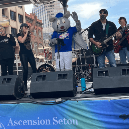 Band performing outdoors with mouse mascot
