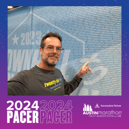 Runner pointing to name on marathon wall