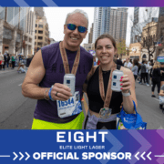 Two runners with medals holding cans