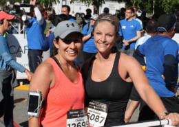 Two smiling women runners at race finish
