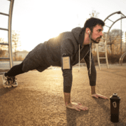 Athletic man in hoodie performing outdoor push-ups