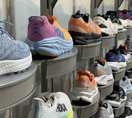 Colorful Hoka running shoes displayed on store shelves