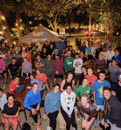 Large group of runners gathered outdoors at night
