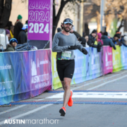 Runner crossing Austin Marathon finish line