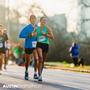 Smiling female runner leading Austin Marathon pack