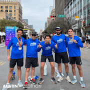Five runners posing after Austin Marathon finish