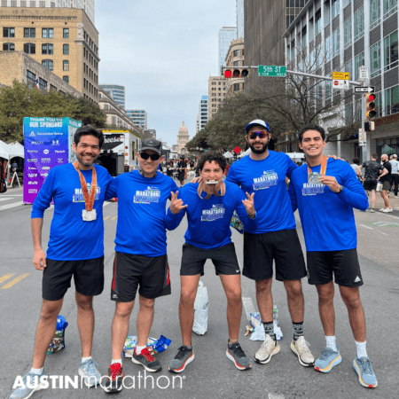 Five runners posing after Austin Marathon finish