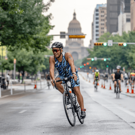 Cyclist racing on city street with capitol