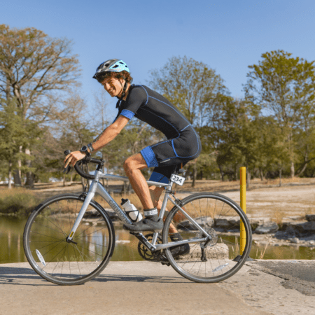 Smiling cyclist wearing helmet on road bike