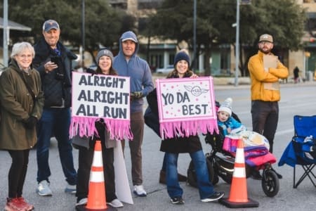 Group of supporters holding encouraging race signs