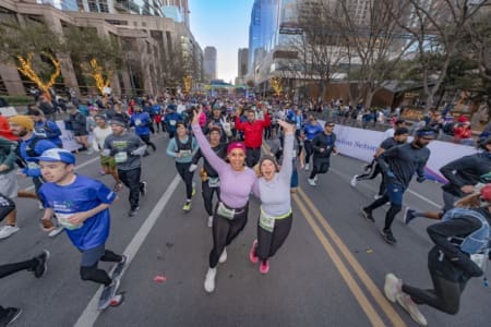 Two women leading crowded city road race