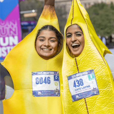 Two smiling marathon runners in banana costumes Two smiling marathon runners in banana costumes