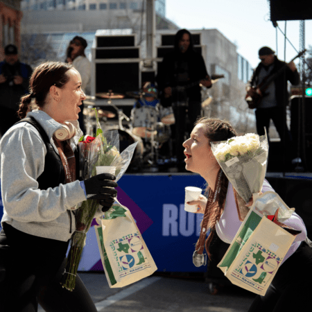 Two women exchanging flowers and gift bags Two women exchanging flowers and gift bags