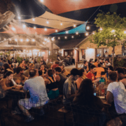Crowded outdoor evening patio with string lights
