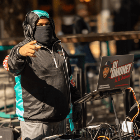 Masked DJ performing outdoors with laptop Masked DJ performing outdoors with laptop