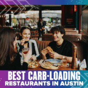 Three friends enjoy pizza and drinks at a restaurant in Austin, smiling and laughing together. The image is overlaid with the text “Best Carb-Loading Restaurants in Austin.”. Austin Marathon Half Marathon & 5K