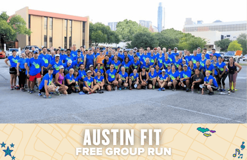 A large group of people in matching blue shirts pose together in a parking lot for a group photo. The text below reads, "Austin Fit Free Group Run," with a beige map-themed banner highlighting the Austin community spirit. Austin Marathon Half Marathon & 5K