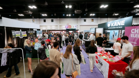 Crowds of people Explore the Expo at the Austin Marathon Expo, walking through a busy hall lined with vendor booths featuring banners, signage, running gear, and products. Some attendees hold bags and interact with exhibitors. Austin Marathon Half Marathon & 5K Crowds of people Explore the Expo at the Austin Marathon Expo, walking through a busy hall lined with vendor booths featuring banners, signage, running gear, and products. Some attendees hold bags and interact with exhibitors. Austin Marathon Half Marathon & 5K