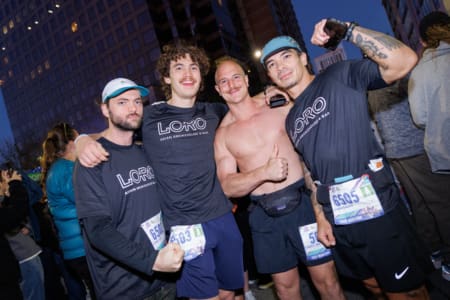 Four runners posing together before a race