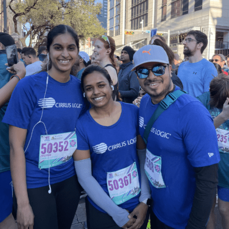 Three people in matching blue "CIRRUS LOGIC" shirts and race bibs smile at the camera in a crowd of runners, showing their excitement as part of the Austin Marathon team program and ready to enjoy team perks and rewards. Austin Marathon Half Marathon & 5K Three people in matching blue "CIRRUS LOGIC" shirts and race bibs smile at the camera in a crowd of runners, showing their excitement as part of the Austin Marathon team program and ready to enjoy team perks and rewards. Austin Marathon Half Marathon & 5K