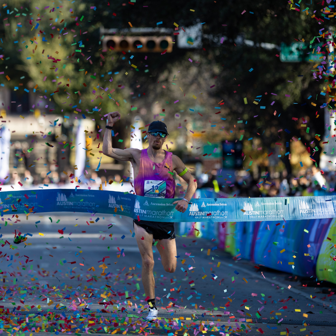 A runner in a pink tank top celebrates crossing the Austin Marathon finish line, surrounded by colorful confetti, with blurred spectators and banners highlighting the event’s rich history in the background. Austin Marathon Half Marathon & 5K A runner in a pink tank top celebrates crossing the Austin Marathon finish line, surrounded by colorful confetti, with blurred spectators and banners highlighting the event’s rich history in the background. Austin Marathon Half Marathon & 5K