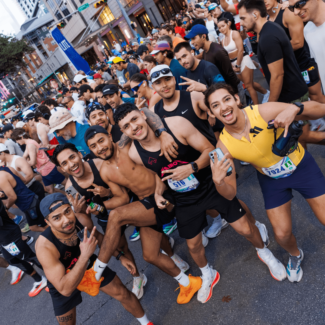 A group of smiling runners pose for a photo at the crowded Ascension Seton Austin Marathon starting line, wearing athletic gear and race bibs, with excited participants and tall buildings in the background. Austin Marathon Half Marathon & 5K A group of smiling runners pose for a photo at the crowded Ascension Seton Austin Marathon starting line, wearing athletic gear and race bibs, with excited participants and tall buildings in the background. Austin Marathon Half Marathon & 5K