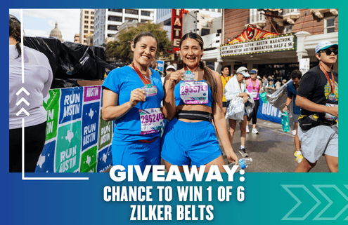 Two smiling women in athletic wear stand holding medals and water bottles at a marathon finish line. Behind them, participants walk by and a banner advertises a Giveaway to win 1 of 6 Zilker Belts. Austin Marathon Half Marathon & 5K