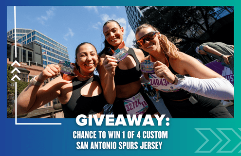 Three smiling runners hold up medals at an outdoor race event. Text reads: "GIVEAWAY: Chance to win 1 of 4 custom San Antonio Spurs jerseys." Urban buildings and trees can be seen in the background. Austin Marathon Half Marathon & 5K