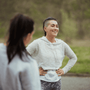Smiling person with hands on hips outdoors