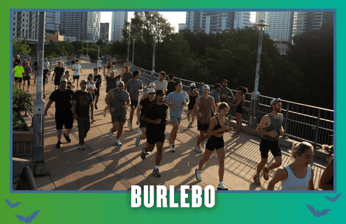 A group of people jog together on a city bridge at sunset, surrounded by tall buildings in South Austin. The word “BURLEBO” appears at the bottom with a teal and green border and small bat graphics, capturing the spirit of a Group Run that motivates everyone to Rise and Run together. Austin Marathon Half Marathon & 5K