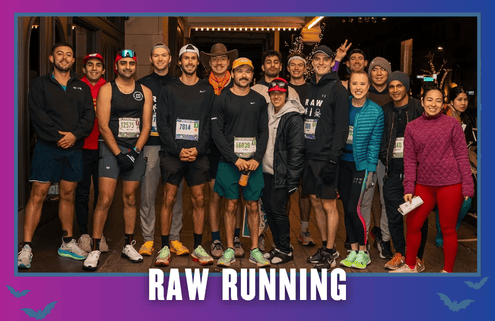 A group of runners in athletic gear pose together and smile at night on a city street under the text “RAW RUNNING.” Representing Latinas Run ATX, some wear hats and race bibs; a few flash peace signs, celebrating the spirit of a vibrant group run. Austin Marathon Half Marathon & 5K