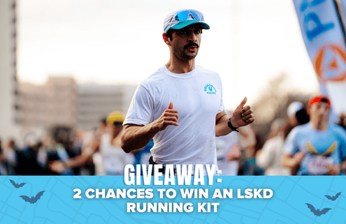 A man running in a race, wearing a white shirt and cap, is featured in the image. The text at the bottom reads, “GIVEAWAY: 2 CHANCES TO WIN AN LSKD RUNNING KIT.” Blue graphics and blurred runners set the background, emphasizing your opportunity to win exclusive prizes—don’t miss out on this exciting giveaway!. Austin Marathon Half Marathon & 5K