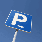 A blue parking sign with a white “P” and a right-pointing arrow, photographed against a clear blue sky, marks convenient access to the Ann and Roy Butler Trail—a favorite in every runner’s guide and one of Austin’s most scenic hike-and-bike trails. Austin Marathon Half Marathon & 5K