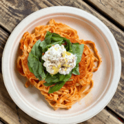 Fettuccine pasta in tomato sauce topped with fresh basil and a dollop of ricotta cheese, making it the best pasta in Austin for pre-run carbs. Austin Marathon Half Marathon & 5K